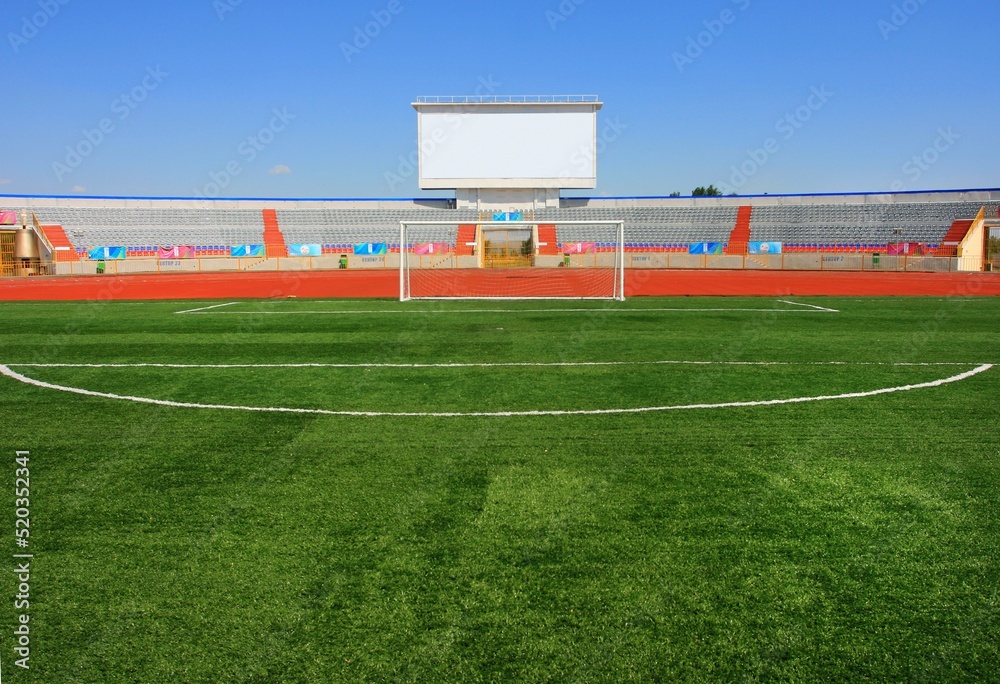 STADIUM - Football field with goal and tablo on blue sky STADIUM - Football field with goal and tablo on blue sky