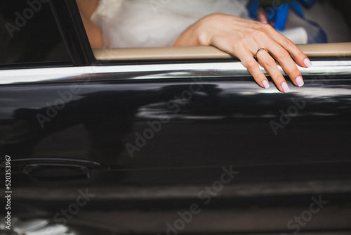 Bride's hand with engagement ring in the car