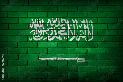 Saudi Arabia flag painted on a brick wall.