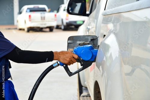 Hand holding the blue diesel nozzle At the gas station, the concept of oil crisis, expensive oil