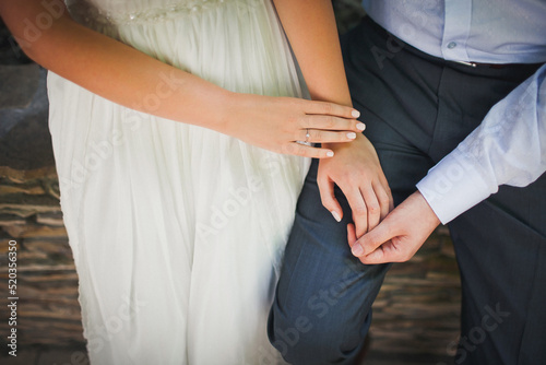 The bride and groom hold each other's hands