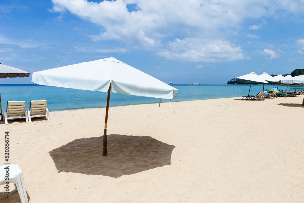 White beach umbrella on tropical beach in south of Thailand, summer outdoor day light, relaxing by the sea