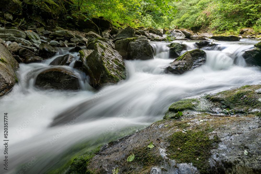 Long exposure of a waterfall on the East Lyn river at Watersmeet in Exmoor National Park Long exposure of a waterfall on the East Lyn river at Watersmeet in Exmoor National Park
