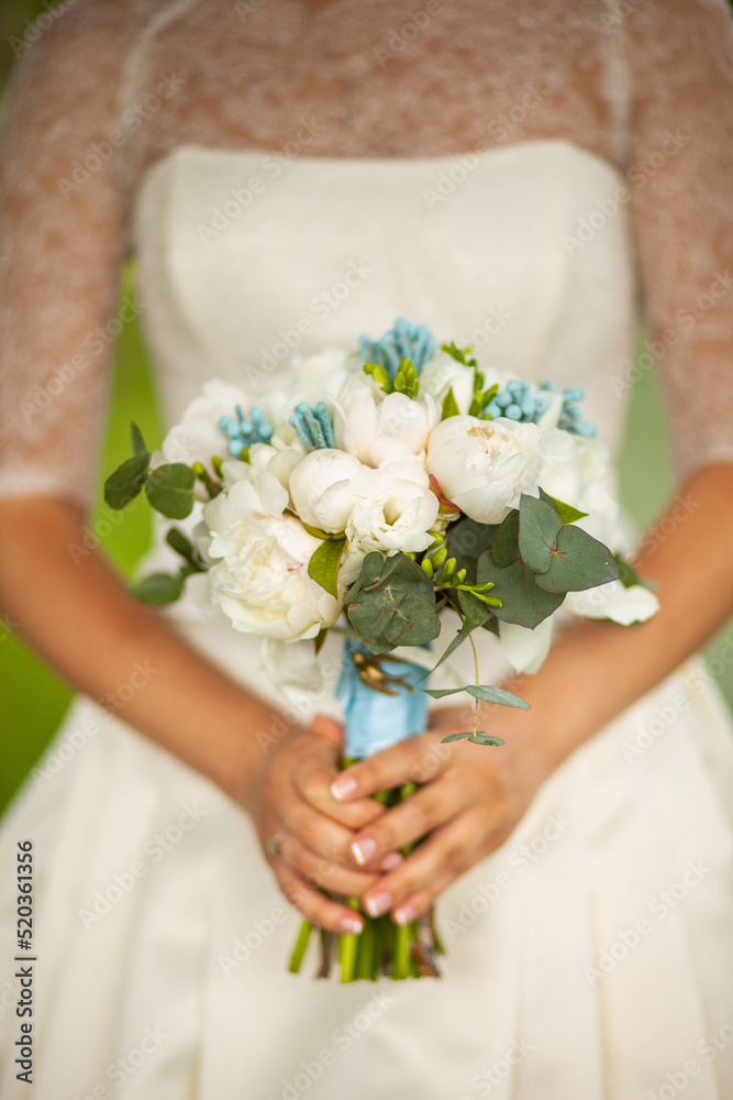 Bright wedding bouquet in hands of the bride