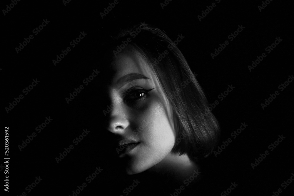 Beautiful female face in the shadows in black and white Beautiful female face in the shadows in black and white