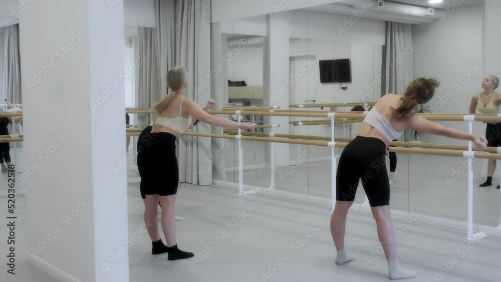 Three young girls dance in a white bright studio in front of a mirror. Slow motion, smooth motion. Graceful movements. 4K. The concept of modern dance. Three young girls dance in a white bright studio in front of a mirror. Slow motion, smooth motion. Graceful movements. 4K. The concept of modern dance.