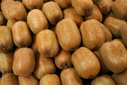 Fresh kiwi fruit as a background. Kiwi or Chinese gooseberry. Detailed hairy texture of this tropical and exotic delicious organic fruit.   