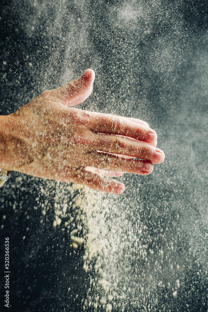 Fototapeta premium Hands with flour on a dark background
