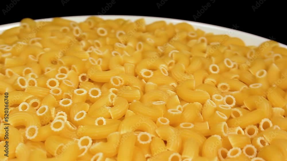 Uncooked Chifferi Rigati Pasta on White Plate Rotating against Black Background. Fat and Unhealthy Food. Classic Dry Macaroni. Italian Culture and Cuisine. Raw Golden Pasta Uncooked Chifferi Rigati Pasta on White Plate Rotating against Black Background. Fat and Unhealthy Food. Classic Dry Macaroni. Italian Culture and Cuisine. Raw Golden Pasta