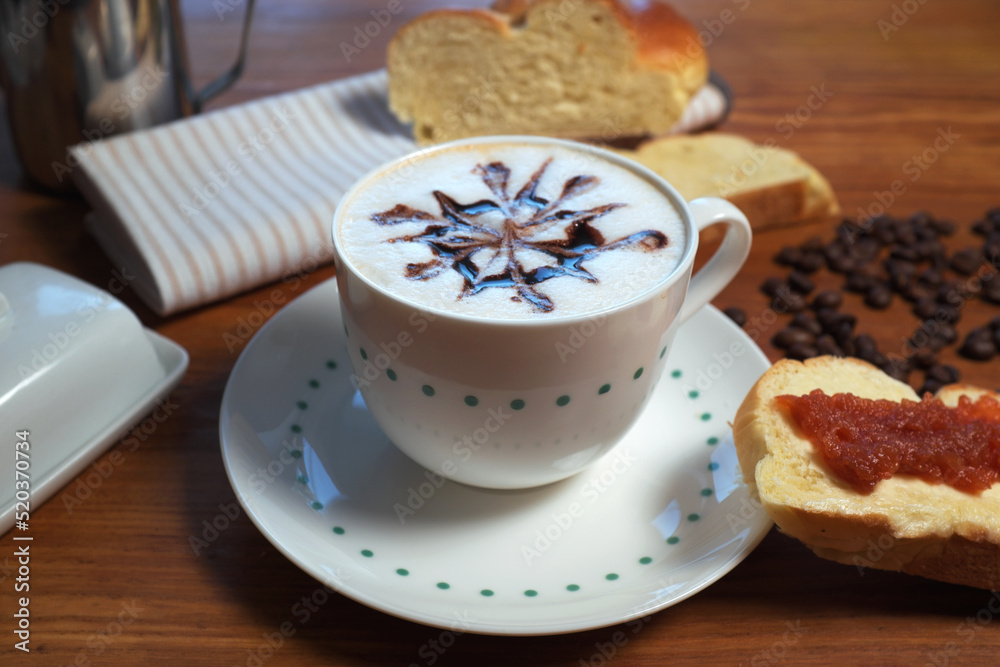 A cup of coffee and a cake with jam ...