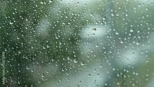 Close-up of Water Drops on Glass of Window. Drops Roll Down During Heavy Summer Rain. Thunderstorm with Strong Gusts of Wind. 4K.