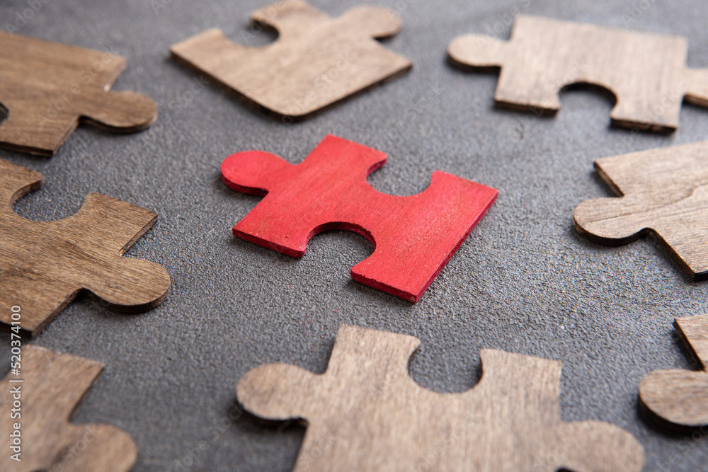 Creative idea and solve the problem concept. Teamwork success strategy - wooden puzzle on the grey background Creative idea and solve the problem concept. Teamwork success strategy - wooden puzzle on the grey background