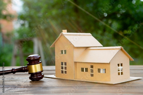 Real estate and protecting insurance concept - Invest to a family home. House model and judge gavel