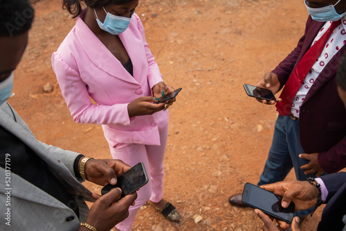 During the Covid 19 pandemic, four colleagues use their cell phones while on a work break