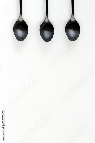 A set of black teaspoons isolated on a white background.