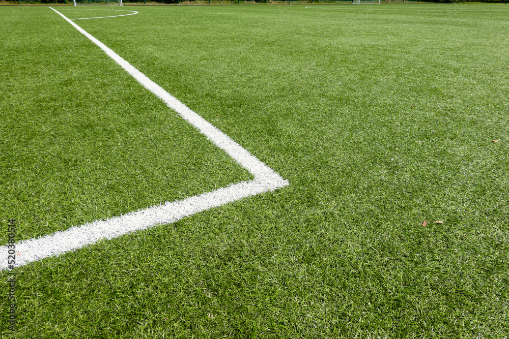 Obraz premium Green synthetic artificial grass soccer sports field with white corner stripe line