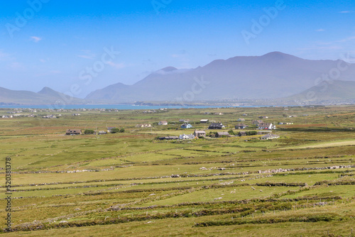 landscape with mountains, fields and houses on the dingle peninsula of county kerry in ireland on the wild atlantic way
