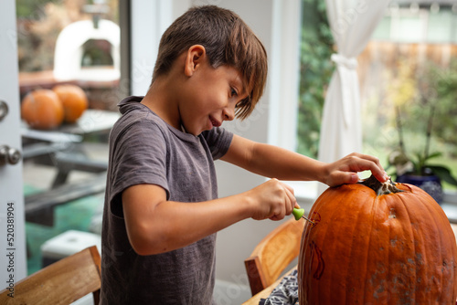 Φωτογραφία child carving pumpkin