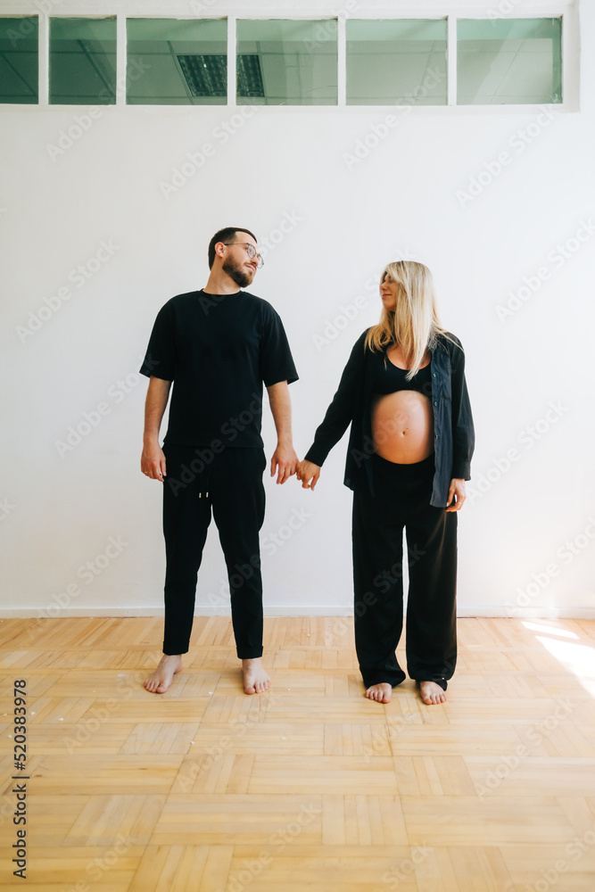 Fototapeta premium Portrait of future mother and father, husband hug pregnant wife. Happy family resting at home
