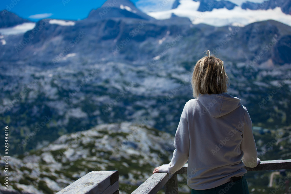 Traveler at Panorama Richtung Dachstein, Dachstein Mountains and enjoys the landscape in Austria, Mountains - extreme wide panoramic. Dachstein