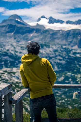 Traveler at Panorama Richtung Dachstein, Dachstein Mountains and enjoys the landscape in Austria, Mountains - extreme wide panoramic. Dachstein