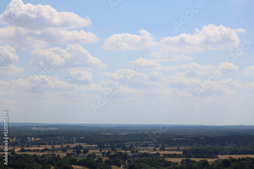 English countryside with field in foreground and blue sky with copy space