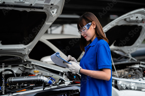 Portrait of a professional female auto mechanic repairing a car. Service concept. Auto repair service concept. © KANGWANS