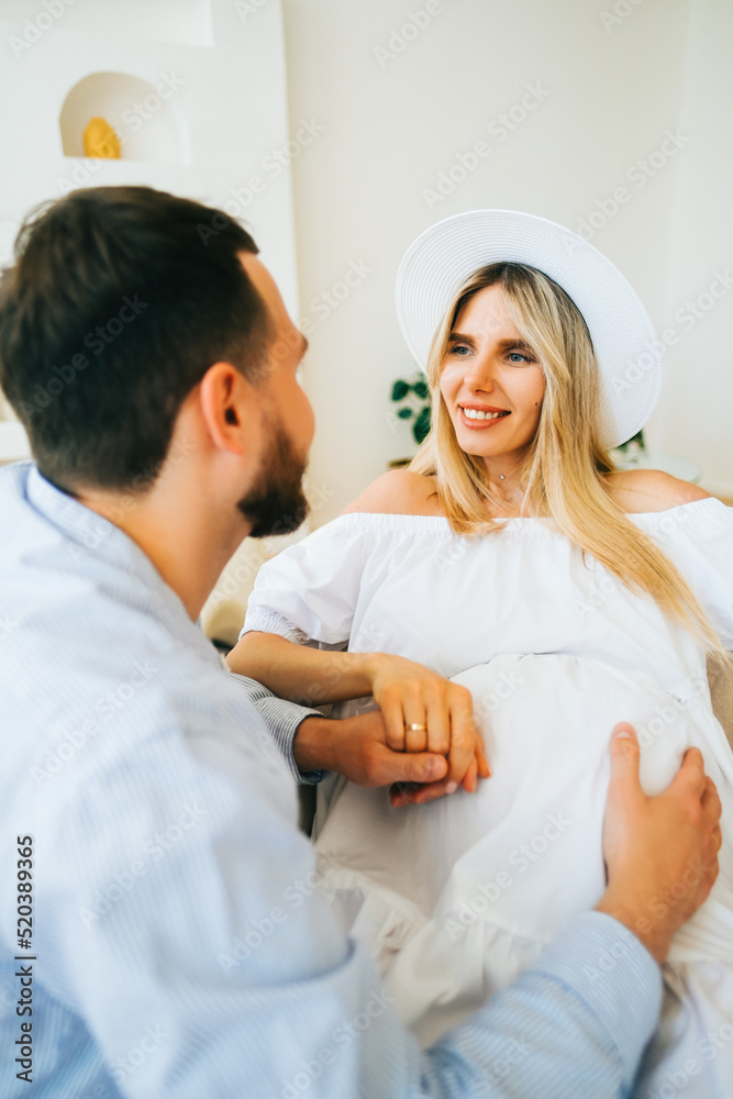 Obraz premium Future mother and father clasped pregnant big tummy. husband hugs pregnant wife. Happy family resting at home