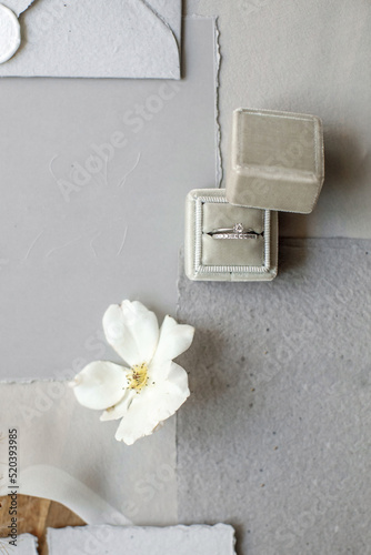 Wedding rings in a box and vintage invitations on the table