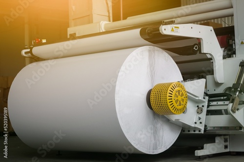 Modern machine for cutting large rolls of white paper for printing houses with roll high-speed printing machines. Selective focus