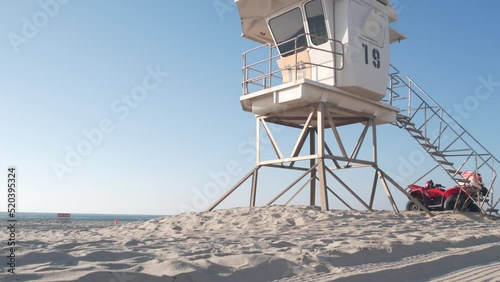 Lifeguard stand or life guard tower hut, surfing safety on California beach, USA. Summer pacific ocean aesthetic. Rescue station, coast lifesavers wachtower or house on sand. Red ATV on Mission beach.