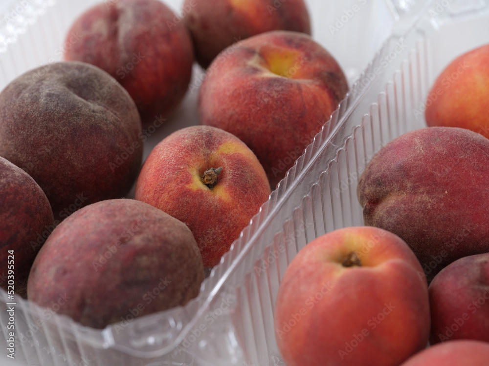 Peaches in plastic containers. Close up.