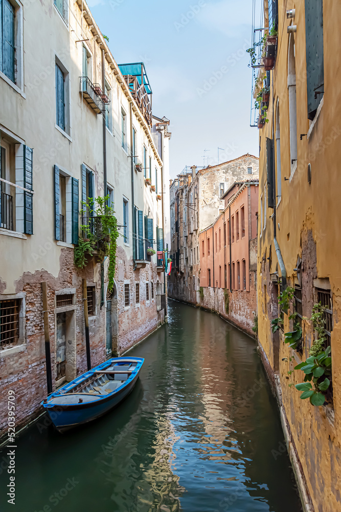 Narrow canal with old colorful houses in Venice, Italy 