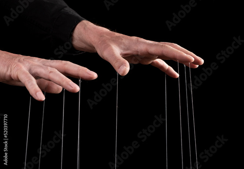 Фотография Hand manipulating and controlling smth with strings concept