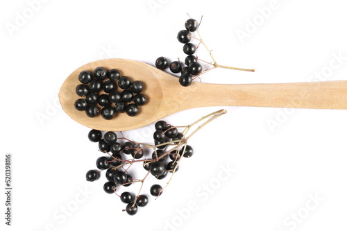 Elderberries, elder berries pile in wooden spoon, isolated on white background, top view