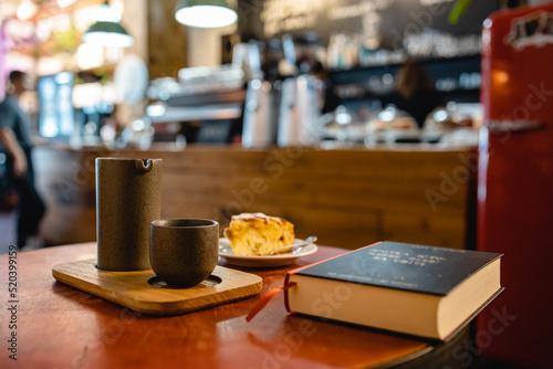 Sunday brunch with coffee and peach cake in a modern loft cafe atmosphere with book in horizontal shot © Богдан Ємець