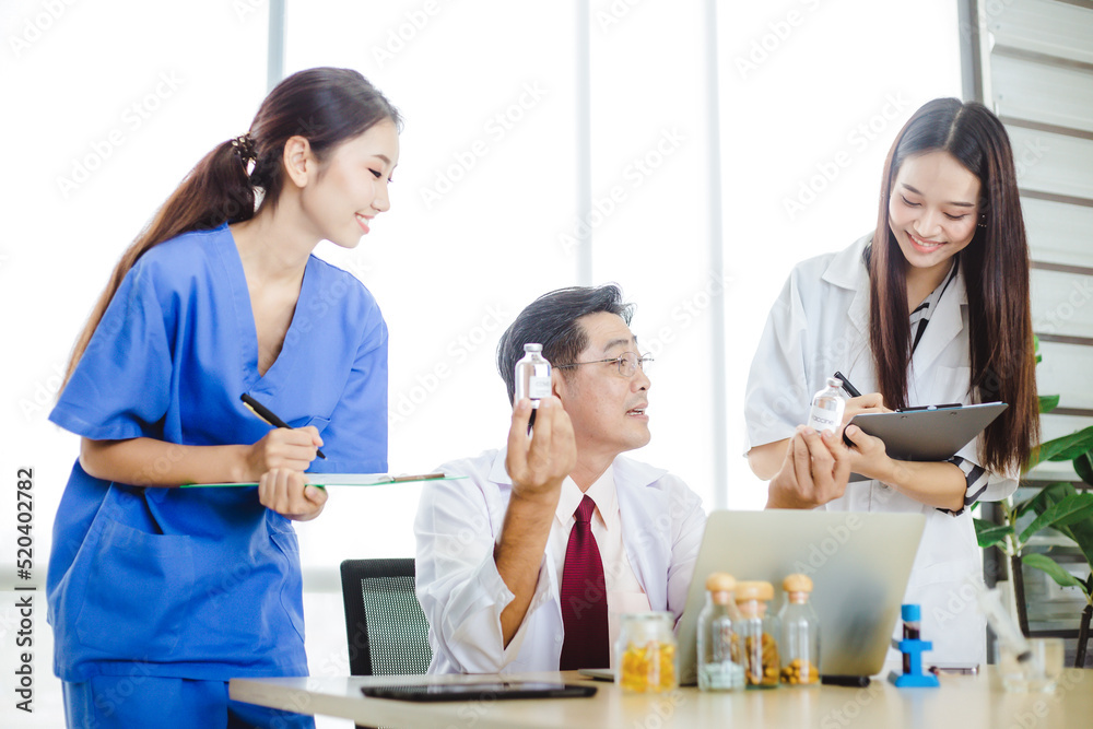 Senior and young doctors having discussion about vaccine and medicine in hospital. Medical team having meeting in modern office. Group of doctors talking and take notes at clinic. Senior and young doctors having discussion about vaccine and medicine in hospital. Medical team having meeting in modern office. Group of doctors talking and take notes at clinic.