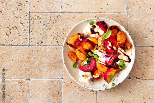 Fruit salad with burrata cheese, honey and herbs. Summer food	