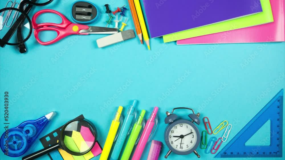 Alarm clock, glasses and school supplies form frame with blank space in the middle. Top view. Stop motion