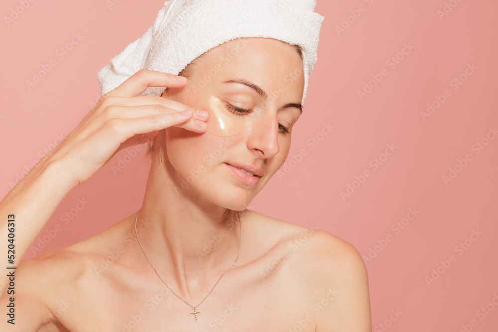 Woman with patches under her eyes touching her smooth skin