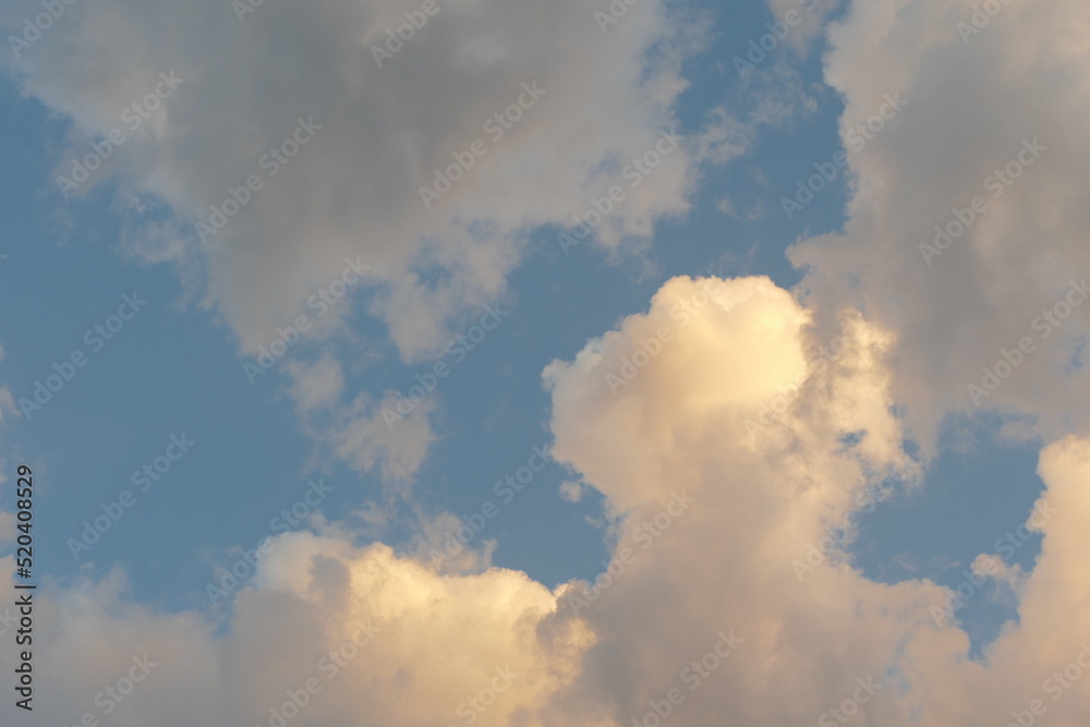 cheerful bright fluffy clouds overhead at dusk