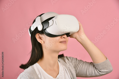 Asian woman using vr glasses, Watching movie and playing video games from virtual reality headset, Young woman amazing with new experience by vr technology, Studio shot.