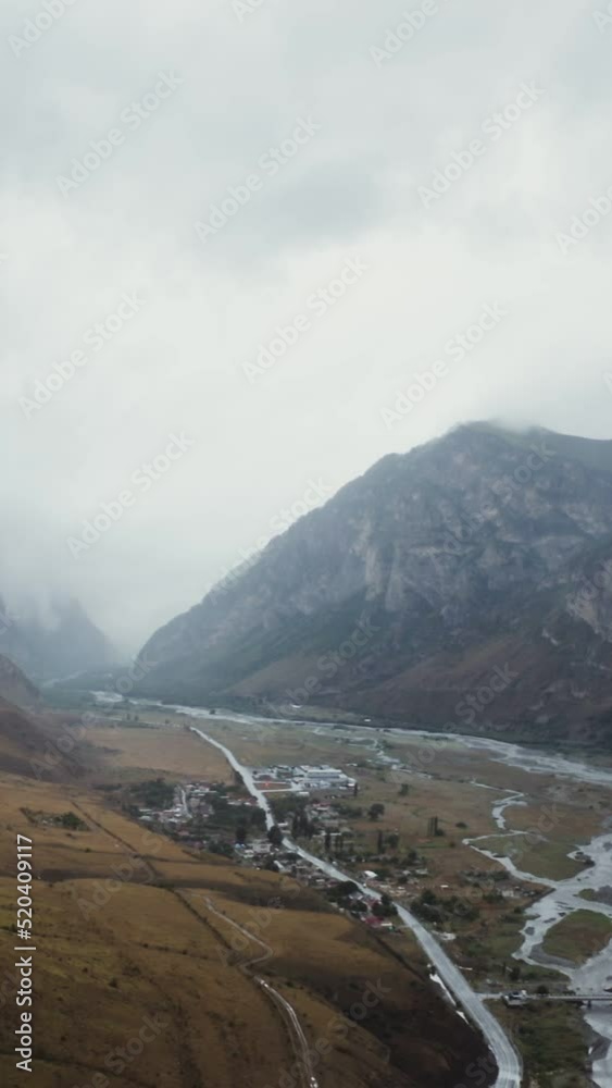 Beautiful view from quadcopter of a mountain valley, with rocky peaks in clouds