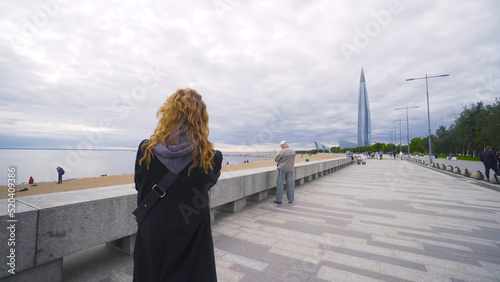Foto Woman photographer walks along embankment