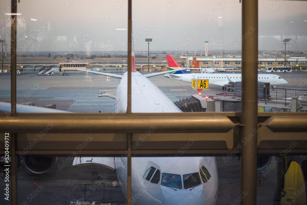 Fototapeta premium Jet aircraft at the boarding gate of Johannesburg International Airport in South Africa, the best airport in the African continent.