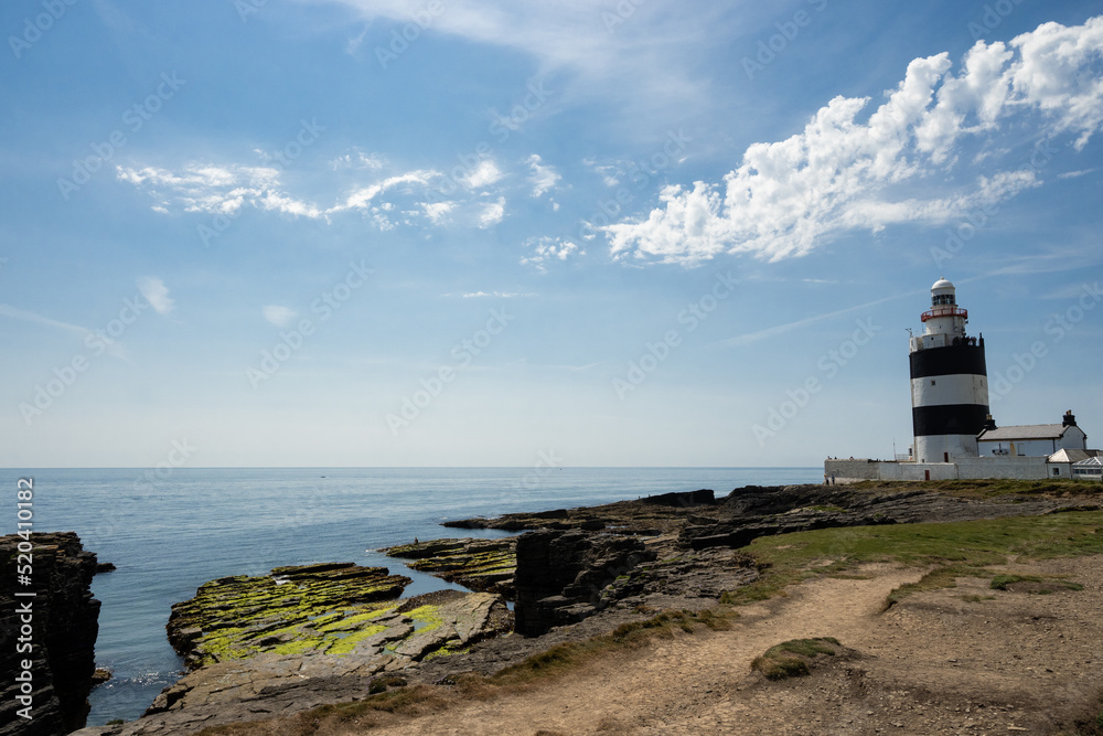 The Hook Lighthouse on the coast of Wexford in Ireland. This building is located on the Hook Head in the Hook peninsula and is the oldest functioning lighthouse in the world. On a sunny day.