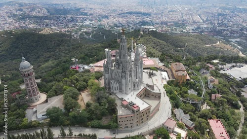 A camera drone flies around the Temple of the Sacred Heart of Jesus and Tower of the Waters of Two Rivers, Barcelona, Spain photo