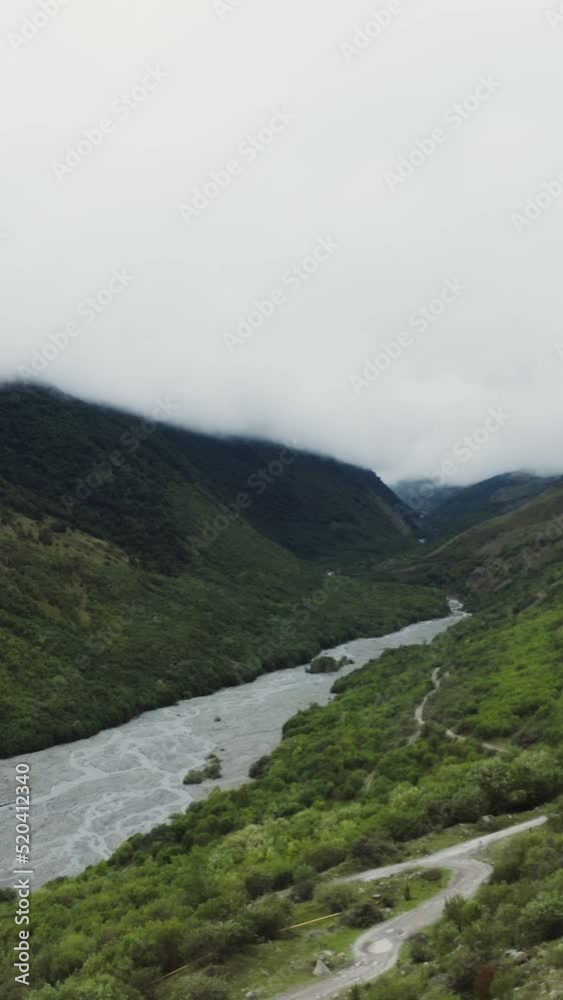 The river flows in the lowlands between the green hills The river flows in the lowlands between the green hills