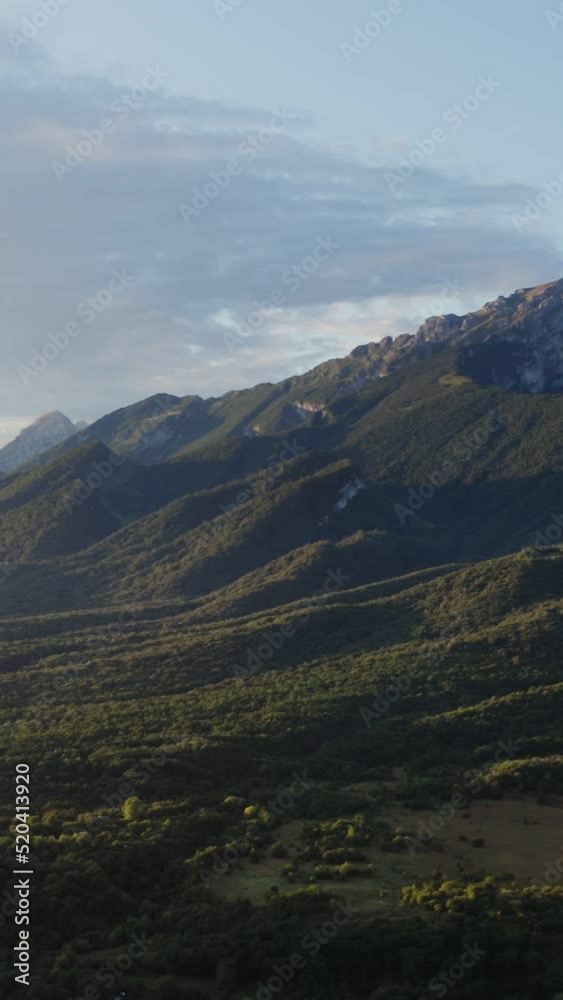 View of mountain valley with hills, with forest against of rocky mountains View of mountain valley with hills, with forest against of rocky mountains