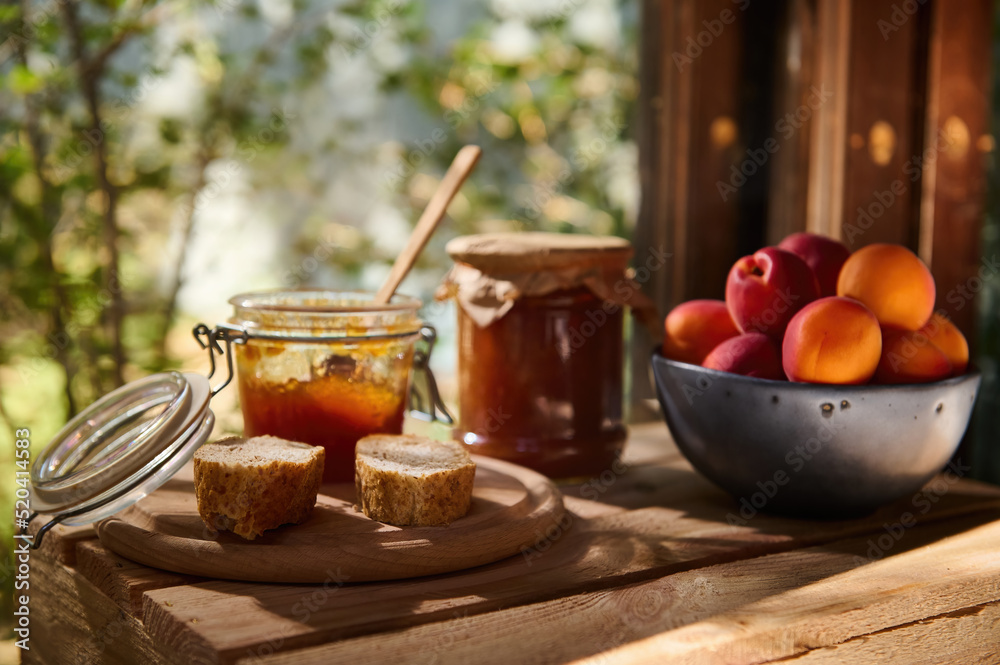 Delicious ripe apricots on wooden table with a jar of apricot jam and slices of homemade bread. Rustic style. Still life Delicious ripe apricots on wooden table with a jar of apricot jam and slices of homemade bread. Rustic style. Still life
